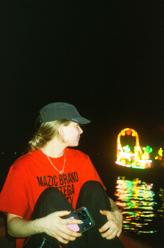 Archive Army Cap in grey blue at night by the water, boat lights behind