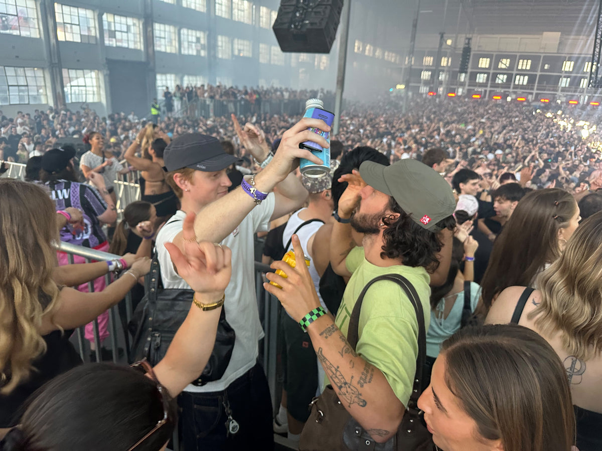 Two Archive Army Caps, grey and khaki green, in a warehouse crowd